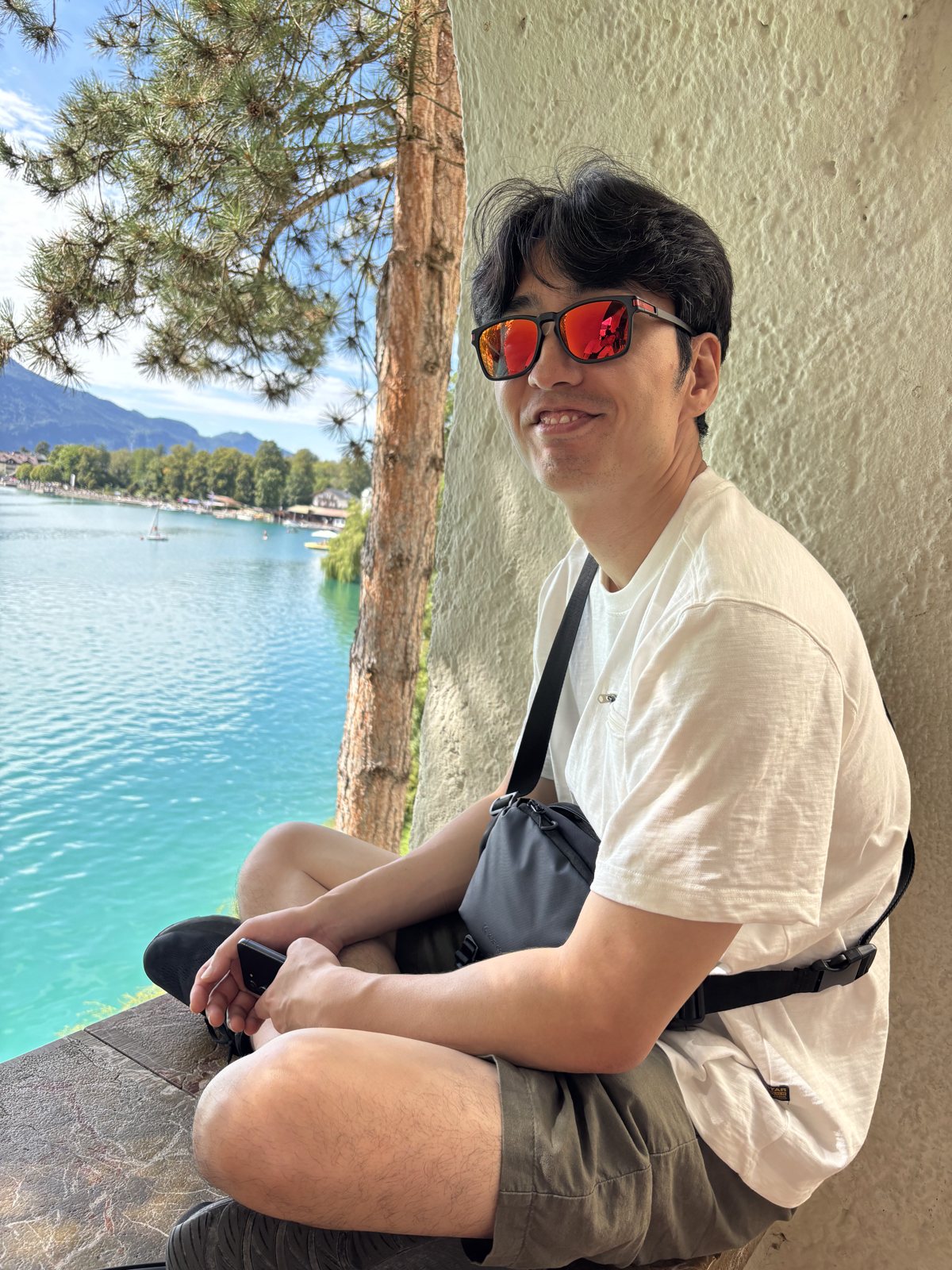 Yunjae in red sunglasses by a turquoise lake