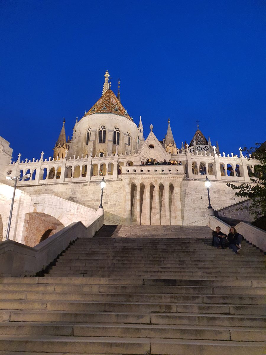 Fisherman's Bastion in Budapest lit up at night, seen from the stairs