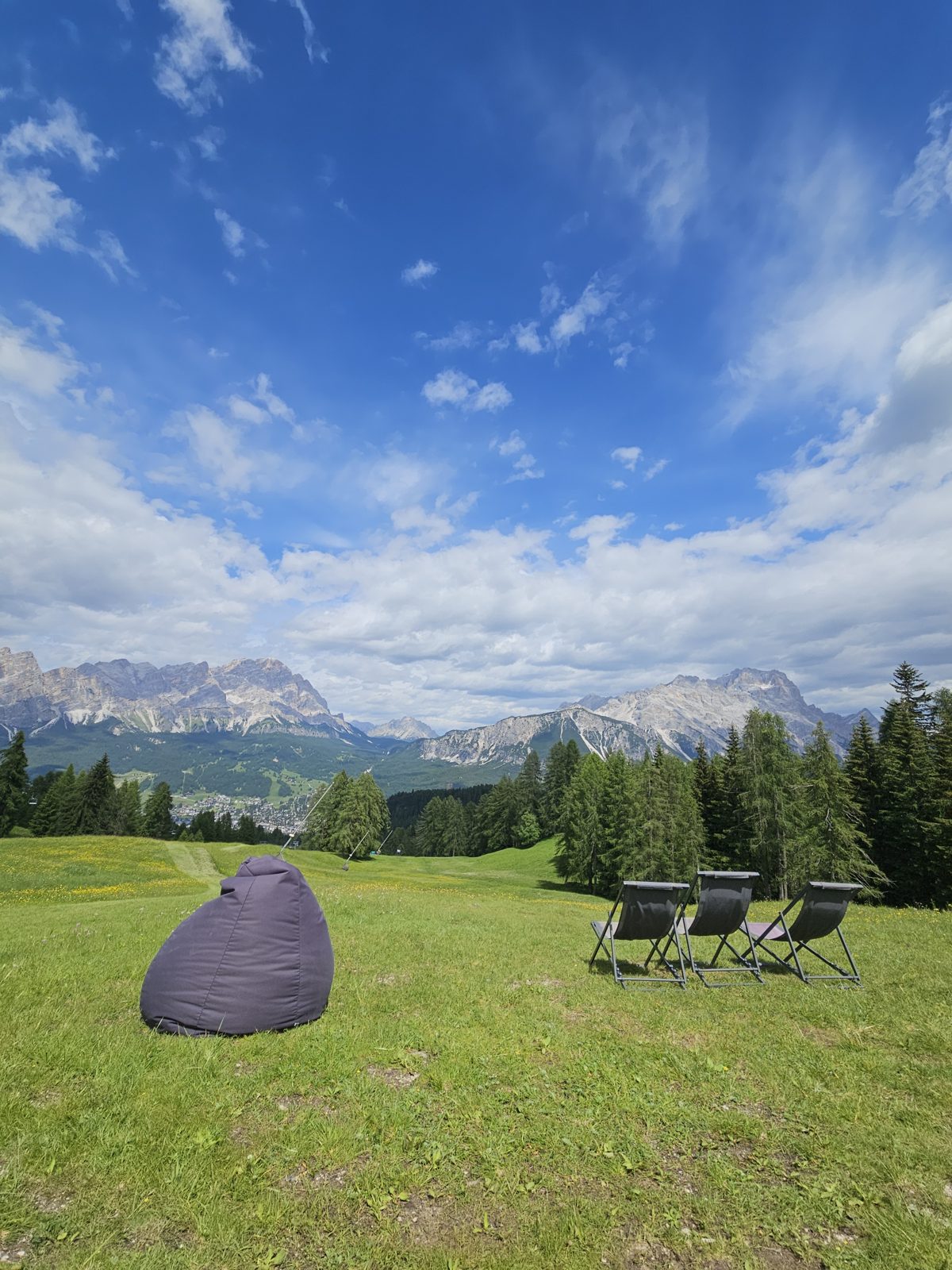 Beanbag and deck chairs on a meadow with Dolomites views