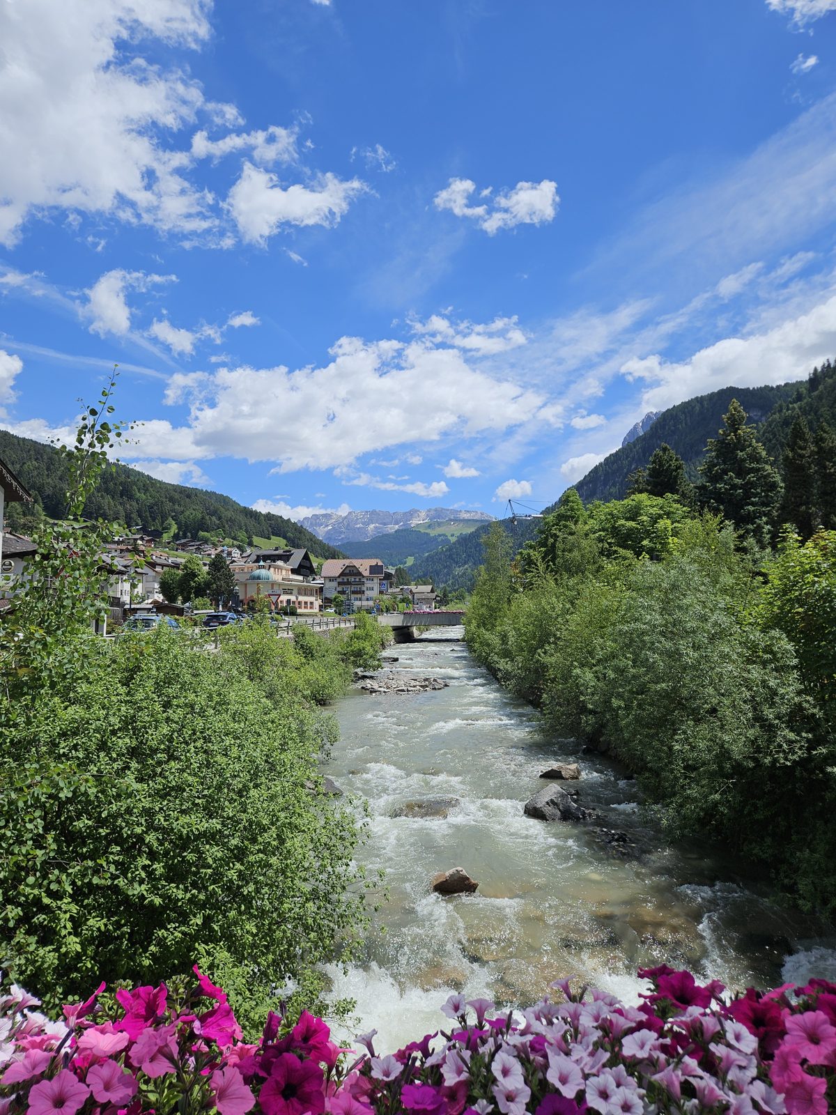 River running through Ortisei in Val Gardena with flowers on the bridge