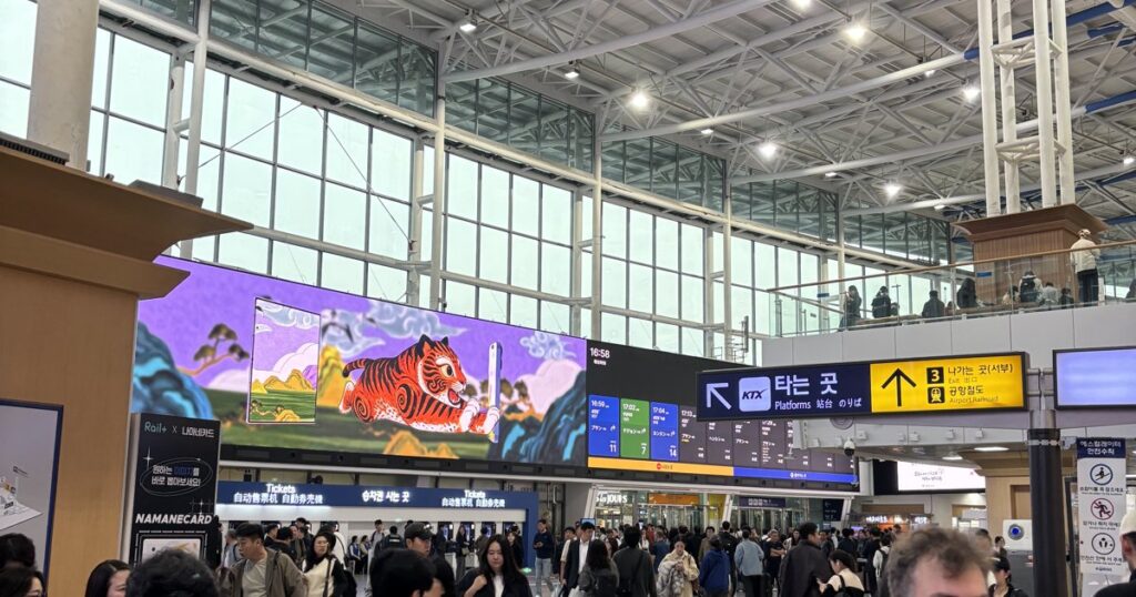 Main hall of Seoul Station with the KTX platforms sign and the big tiger screen
